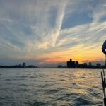 Detroit skyline on the water at sunset.