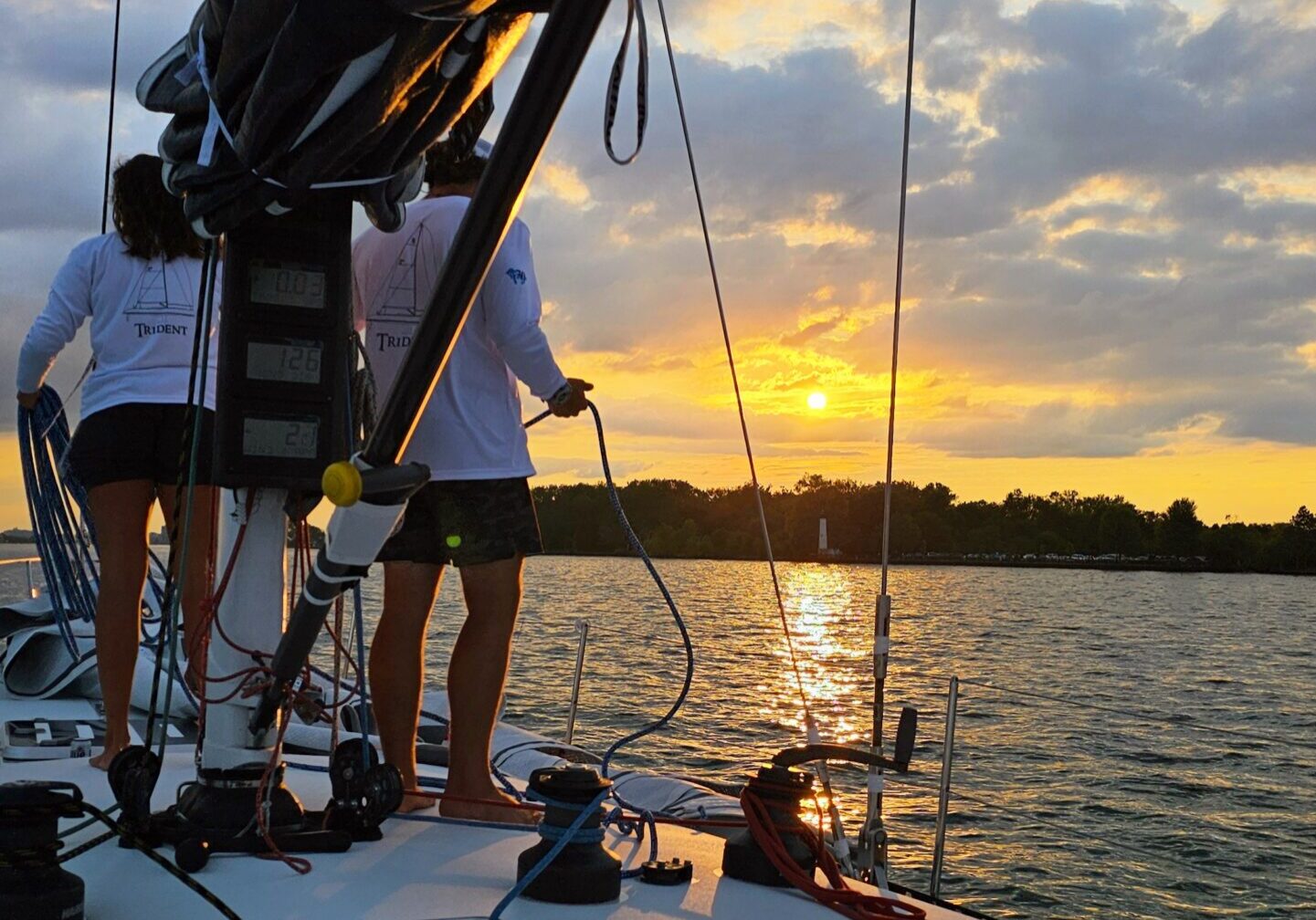 Crew of Sail Boat Charter Looking Out over the water at sunset.